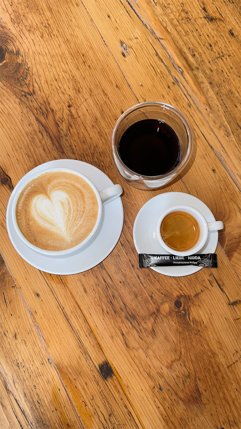 Cappuccino, Espresso und Kaffee auf Holztisch in Rösterei Nidda