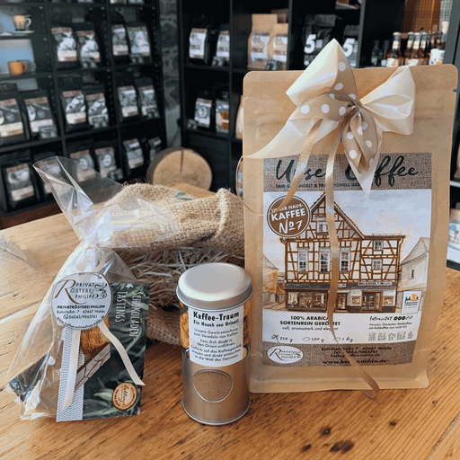 Kaffee-Geschenkset Kaffee & Schokolade der Privatrösterei Philipp mit Kaffee und Schokolade, Kaffeegewürz und Säckchen auf Holztisch 