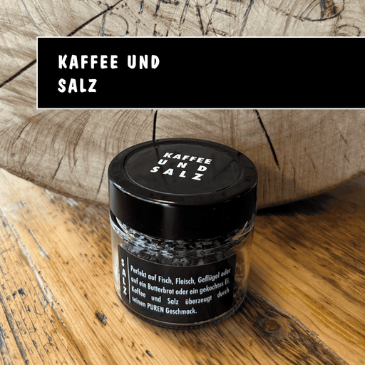 Kleines Glas Gewürzsalz mit Kaffee von Kaffeerösterei Nidda auf Holztisch.